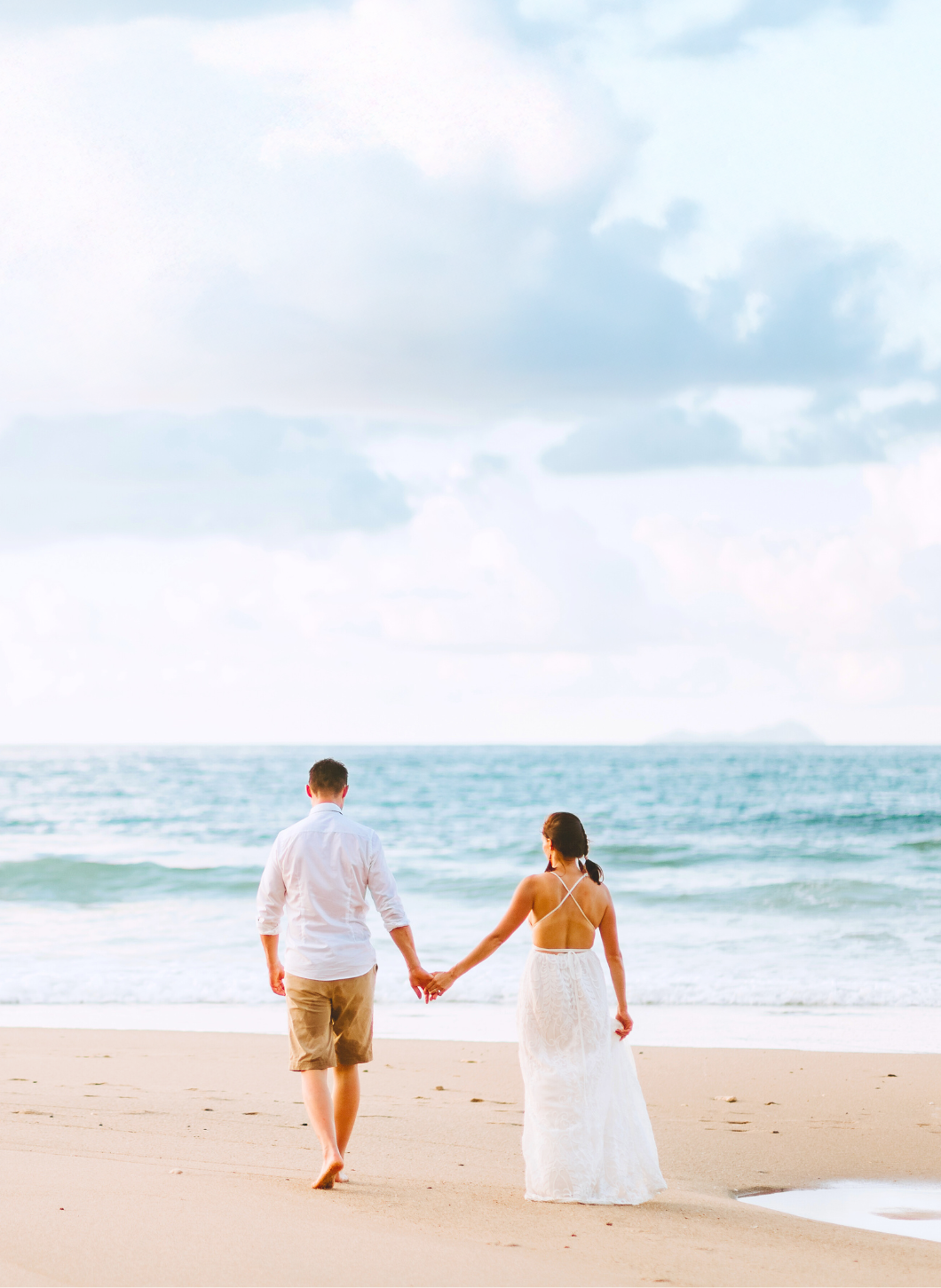 Couple walking on beach — start planning your honeymoon